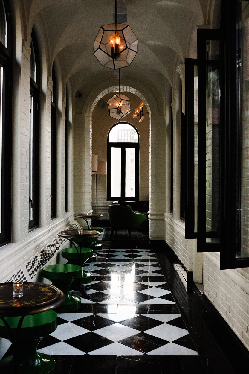 Checkerboard tile hallways lined with french windows on either side anchor the hotel's feel.
